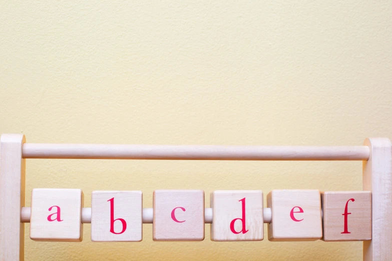 a wooden frame with letters spelling alphabet on top