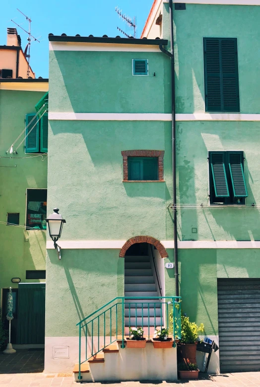 an alleyway with buildings on both sides and green painted