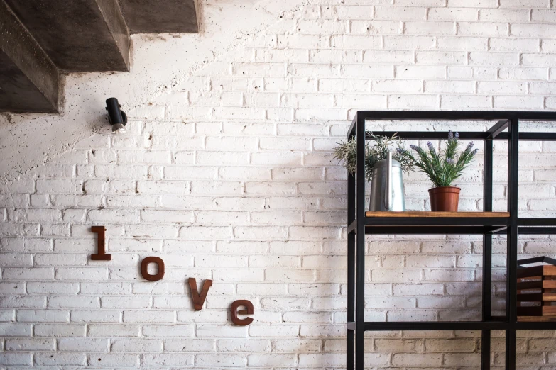 the room has two small shelves with books and vases on them