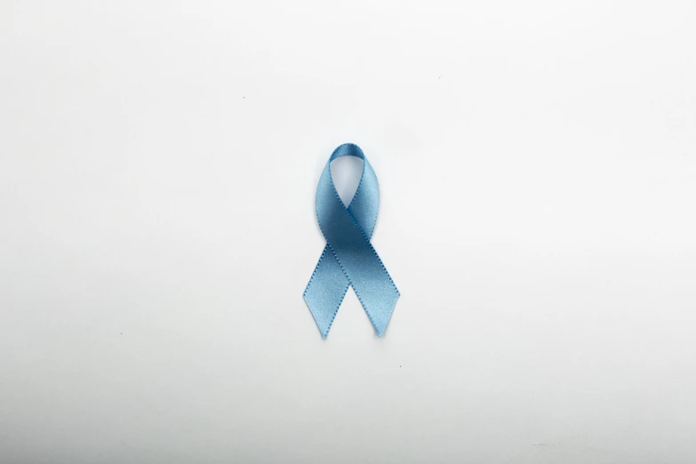 a blue ribbon sitting on top of a white wall