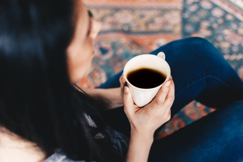 a woman is holding a cup of coffee in her hand