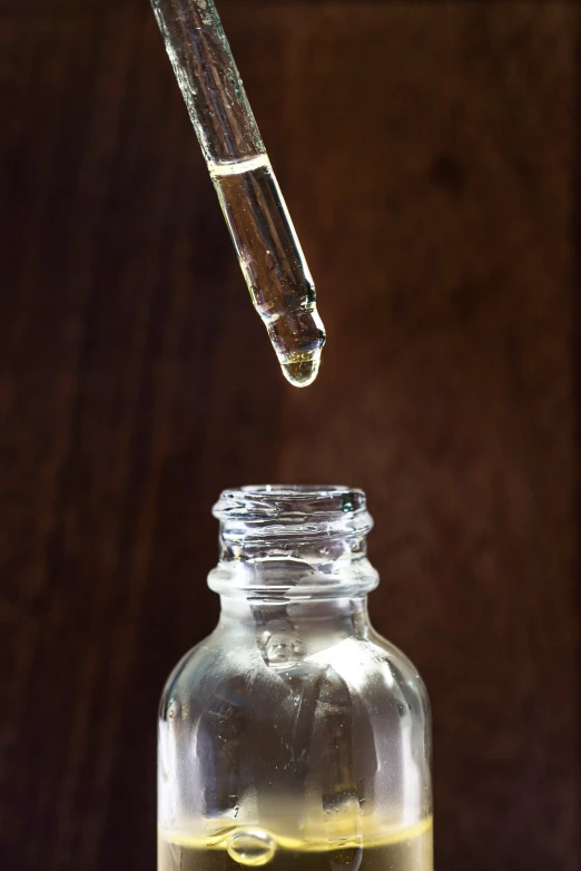 the oil being poured into a small glass jar