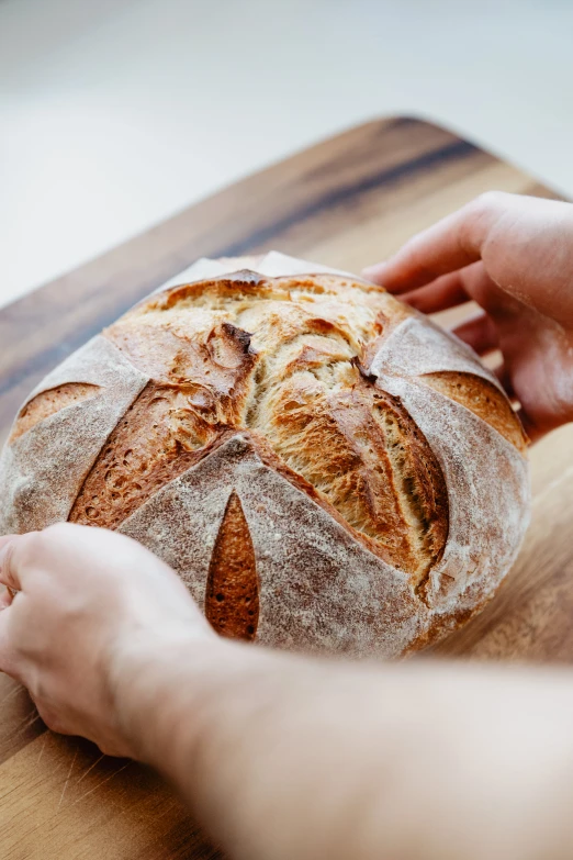 the person is putting bread on top of a board