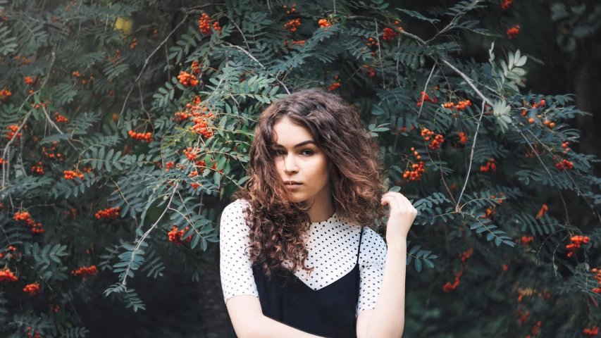 the beautiful brunette woman is posing for a po with berries on her bush