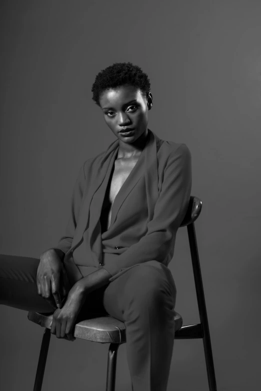 an african woman poses for the camera in a chair