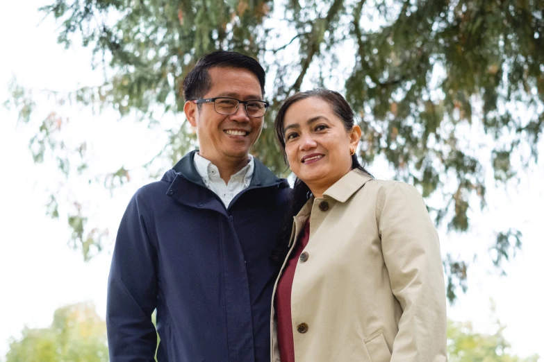 a couple standing together under a tree