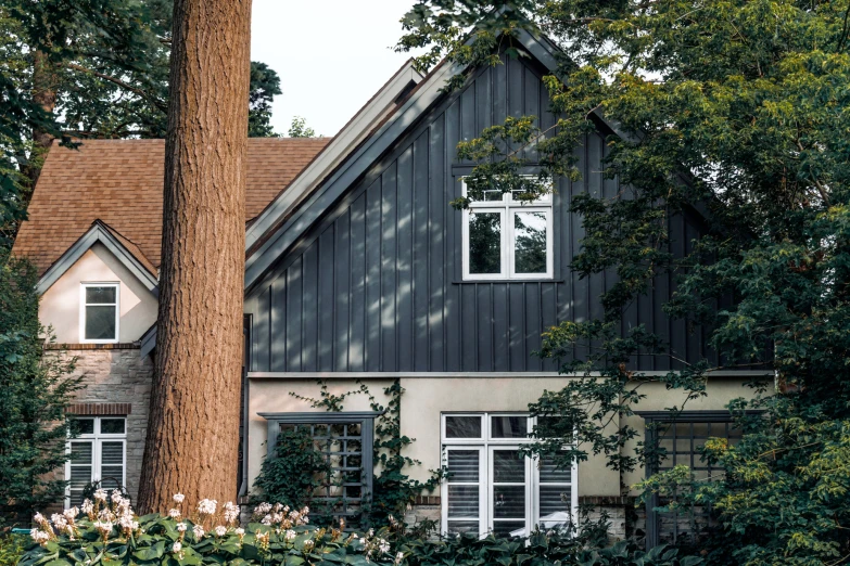 house with gray shingles and white windows in residential area