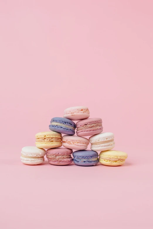 a pile of macaroons against a pink backdrop