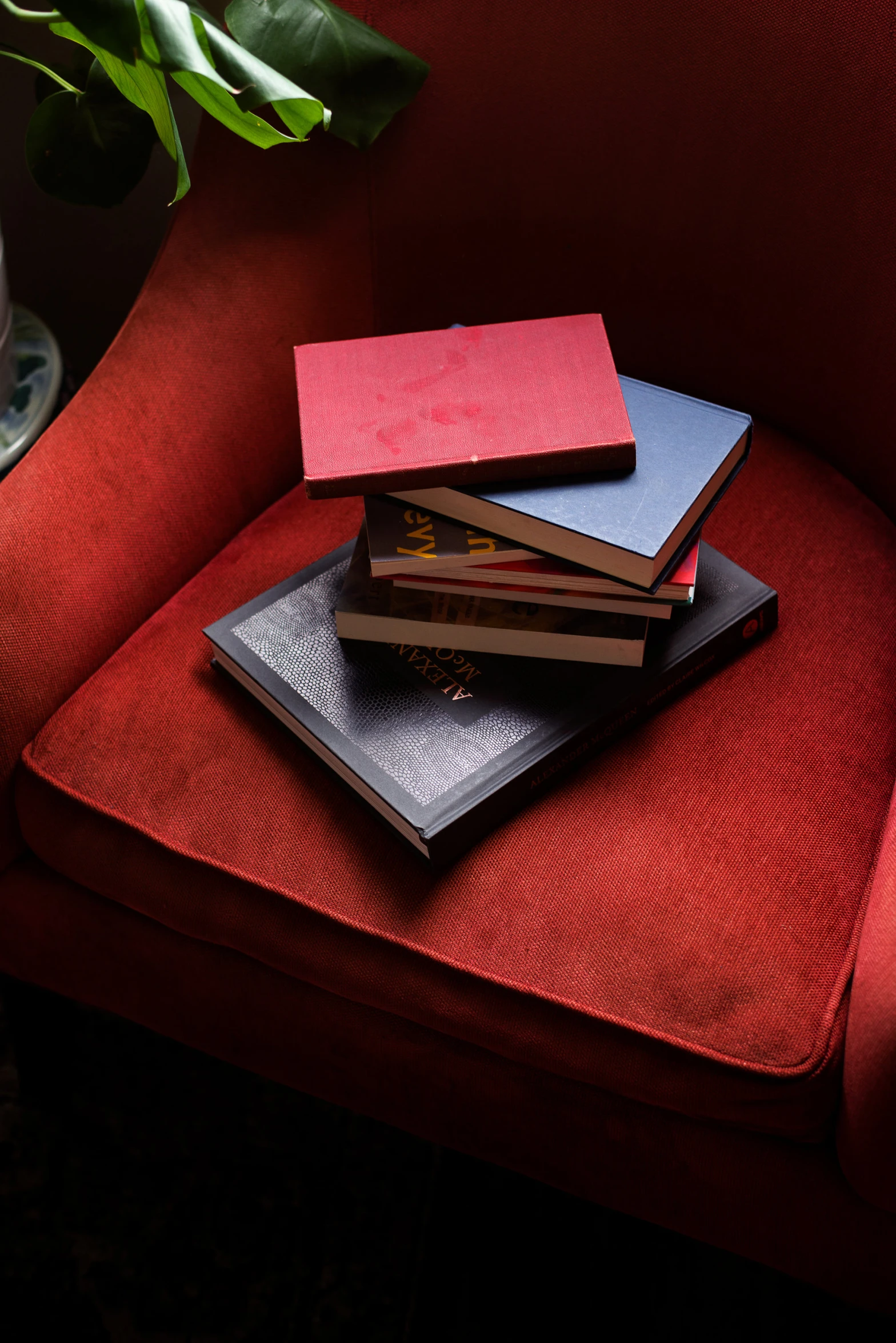 a stack of four notebooks sitting on a red couch