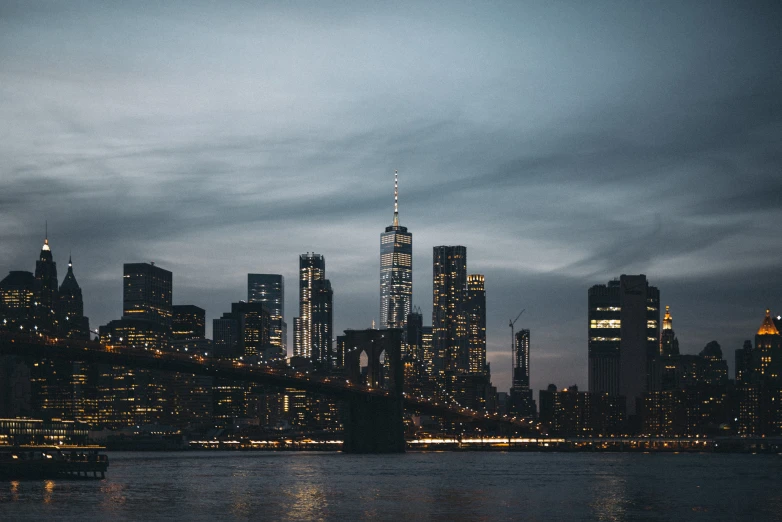 the city lights shine bright on the river near tall buildings