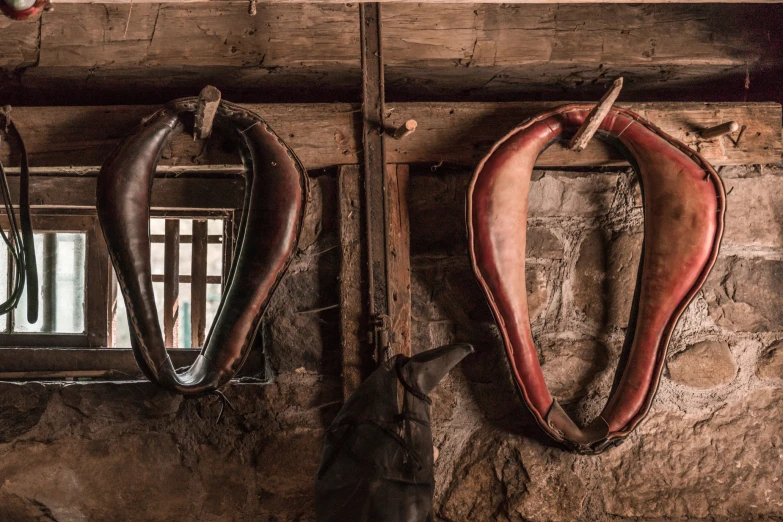 an old, rusted pair of saddles hanging on the wall