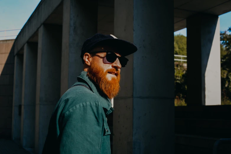 a bearded man with glasses and a baseball hat