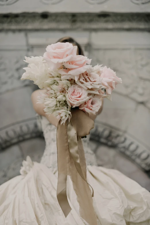 a bride with bouquet of flowers wearing white dress