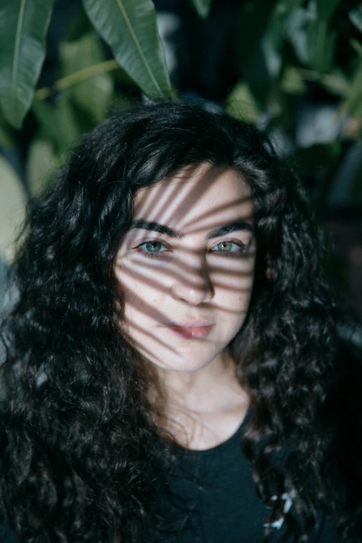 the sun beaming through the blinds of a woman's face