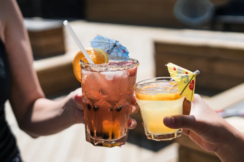 two people hold up two different beverages in their hands