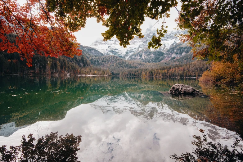 the clouds in the sky reflect on the still lake water