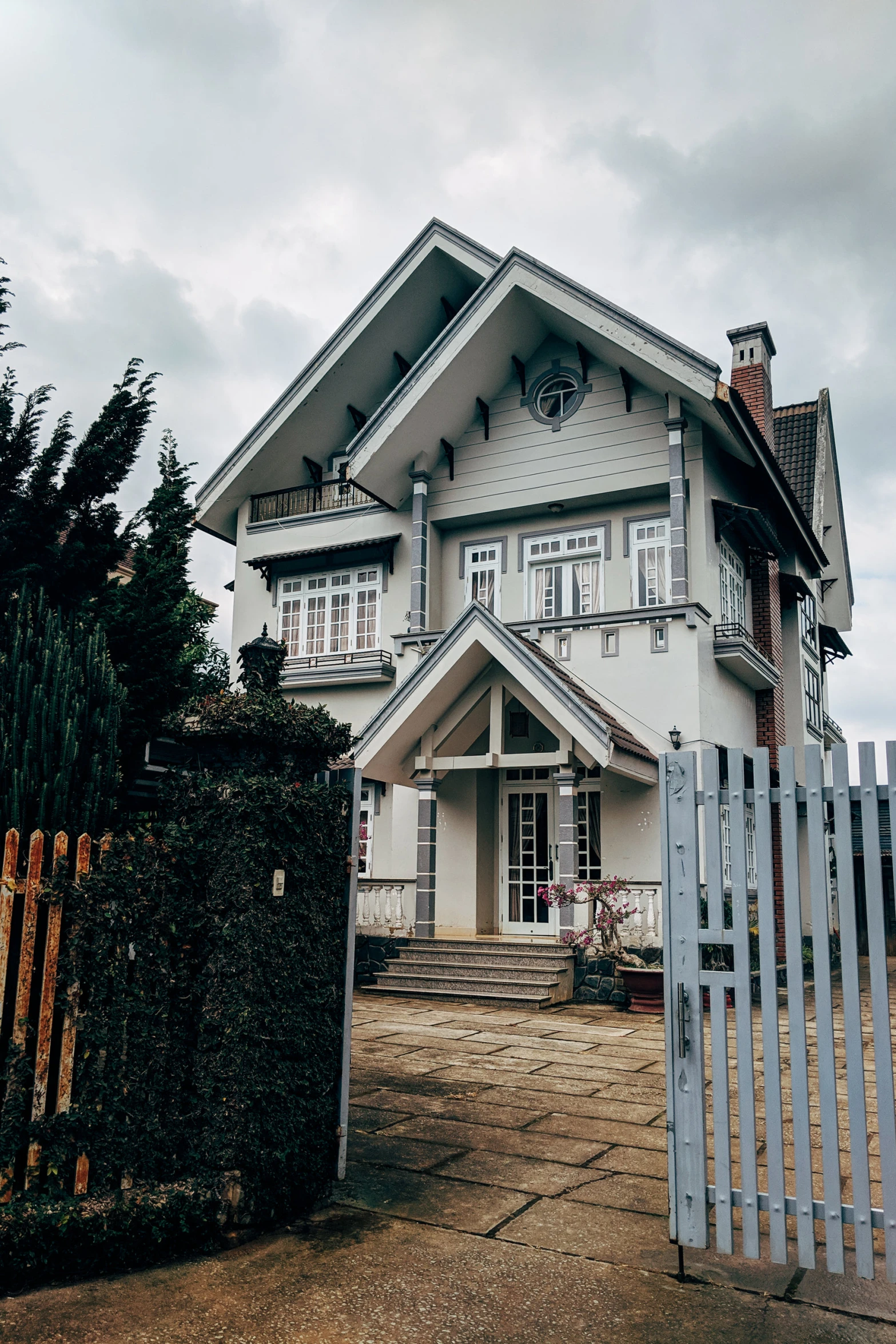 a house sits with a picket fence behind it