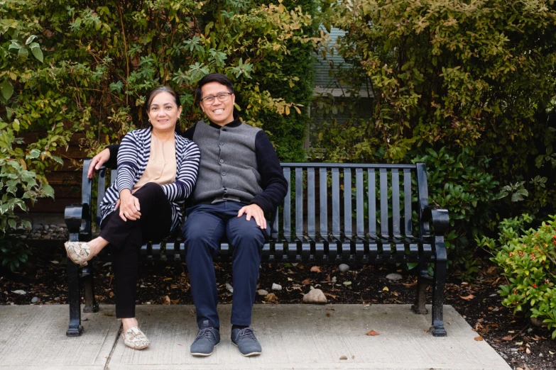 a couple pose for a po on a bench