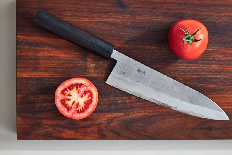 the sliced tomato is sitting on top of a  board