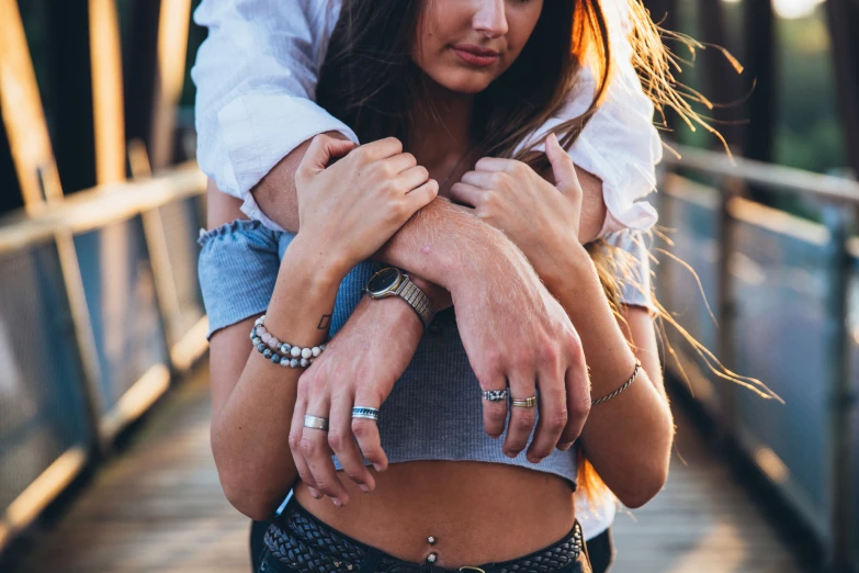 a woman in shorts carries a man onto the pier