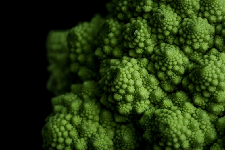 closeup of a bunch of fresh cauliflower on a black background