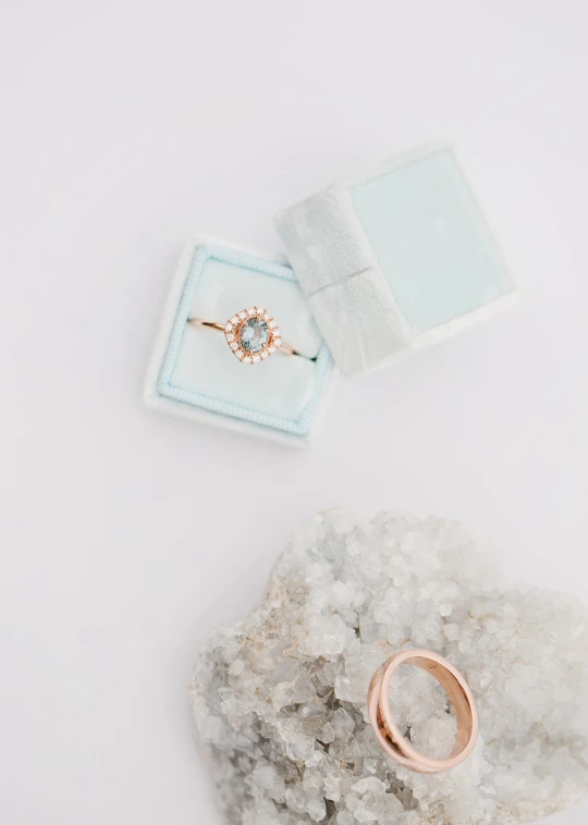 a jewelry ring sitting on top of a rock with a diamond ring in it