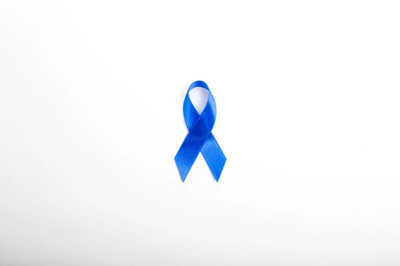 a blue ribbon is placed next to a white wall