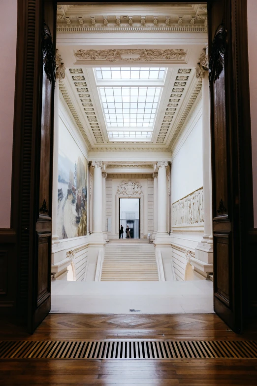 an empty room with columns and a skylight