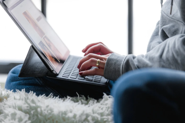 a woman is typing on a laptop computer