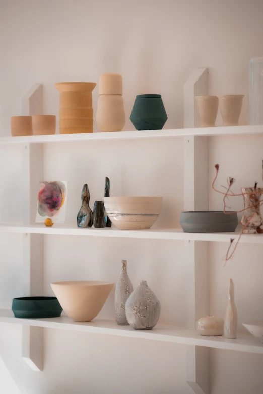 a wall shelves with dishes, vases and vases