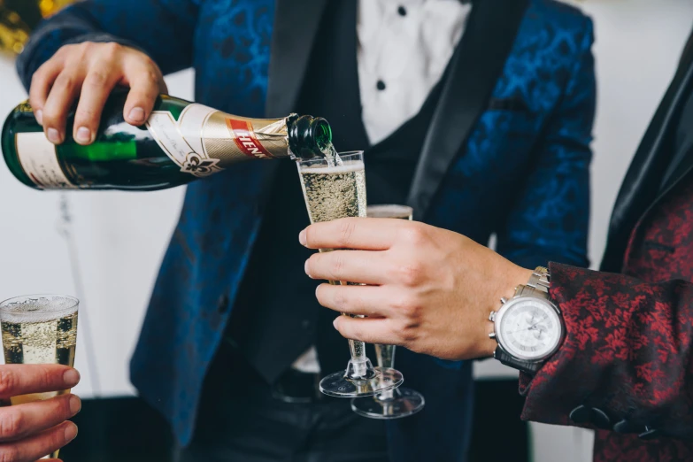 two men pouring champagne into their glasses