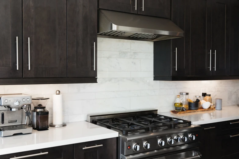 a kitchen area with stove, refrigerator and coffee maker