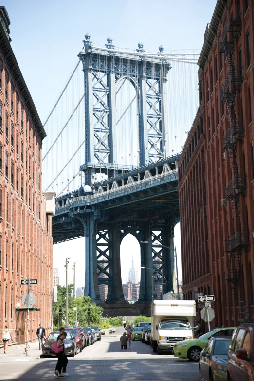 a man riding a bike down a street under a bridge