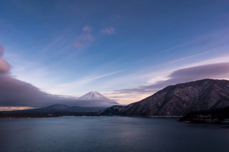 there is a snow capped mountain on the water