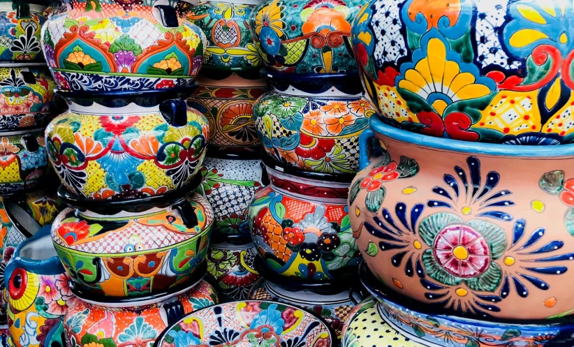 a pile of very colorful jars with designs