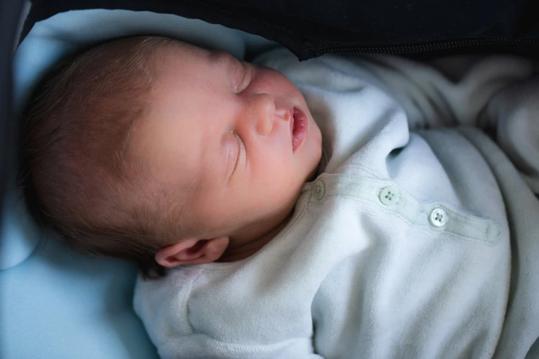 a close up of a baby sleeping in a blanket