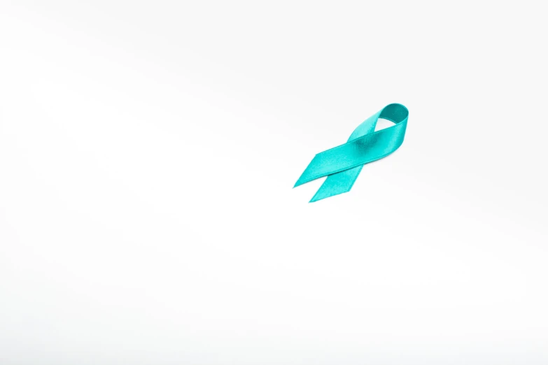 a single teal colored ribbon flying in the air