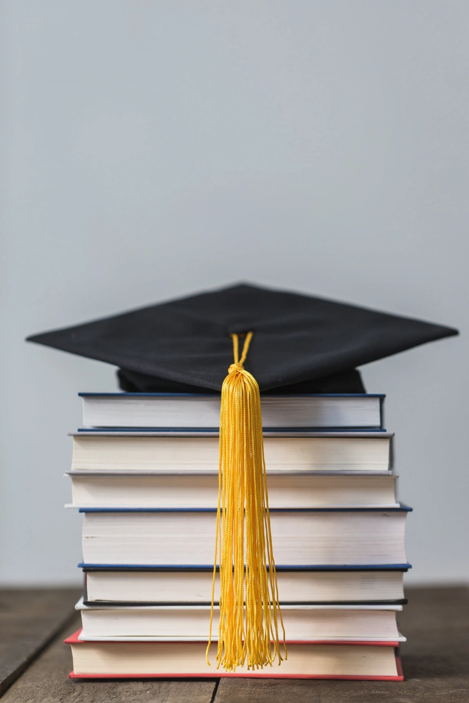 a stack of books with a cap on top