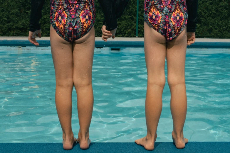 two girls standing in a swimming pool wearing panties