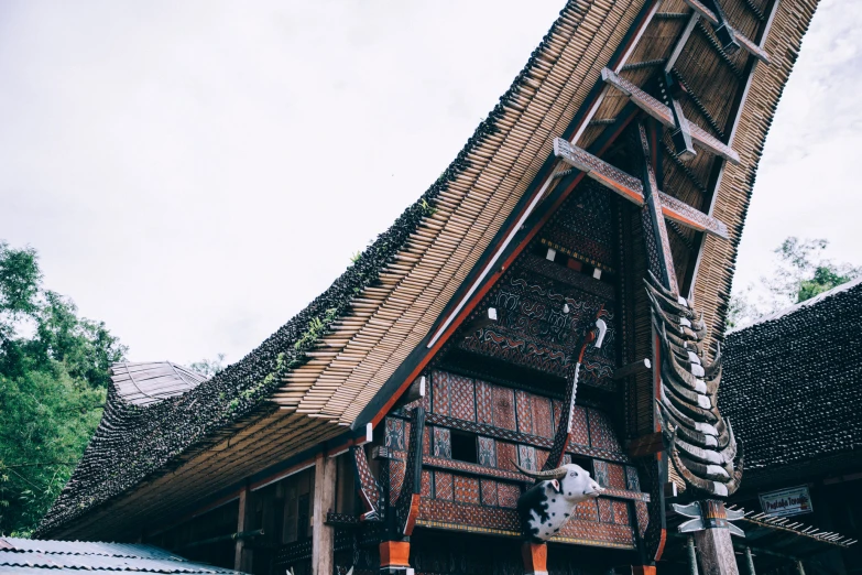 an elaborate building with wooden trims that has an interesting shaped roof