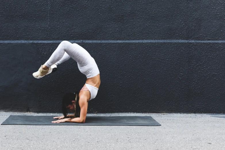 a woman does a handstand on her yoga mat