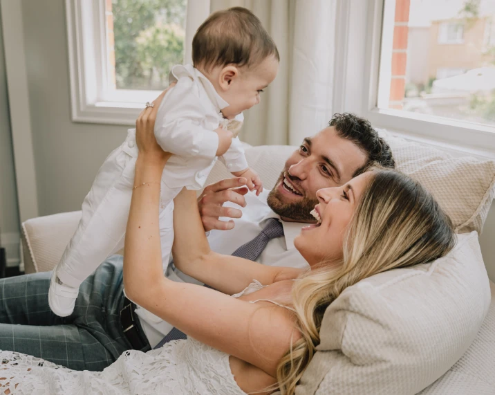 a man sitting with his wife and holding a baby boy