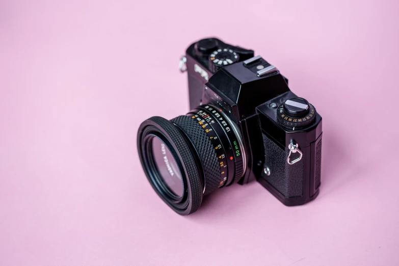 an old digital camera that is sitting on a pink table