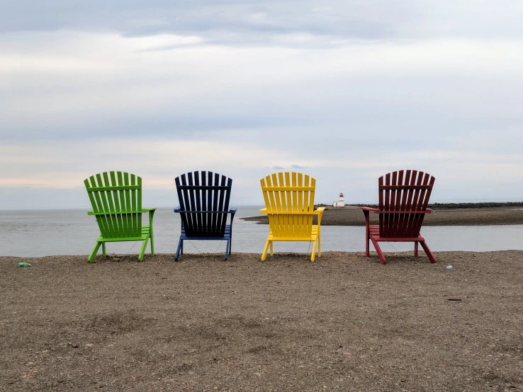 a group of three colorful chairs next to water