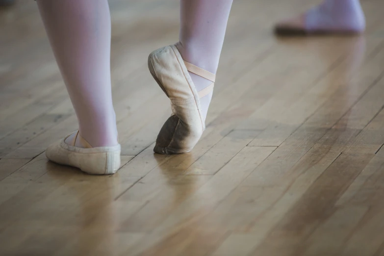 a person is standing on the floor with their feet up and shoes down