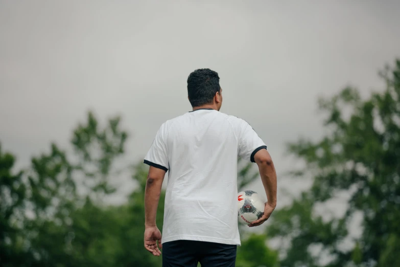 a man standing in a field with a white soccer ball