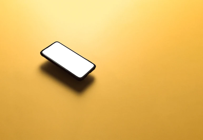 a cell phone laying on a yellow surface