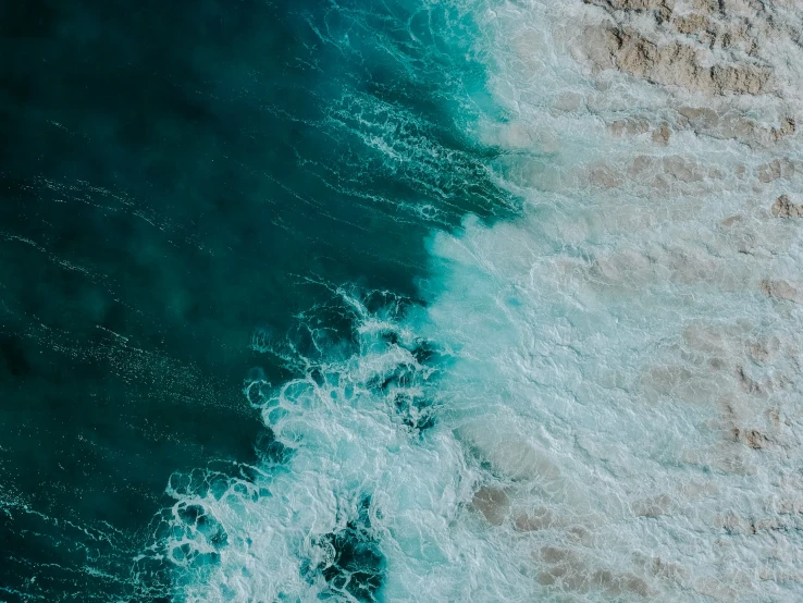 top down view of a rocky cliff with waves crashing in