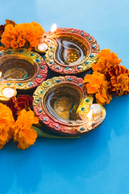 flower petals surround a colorful, decorated diya