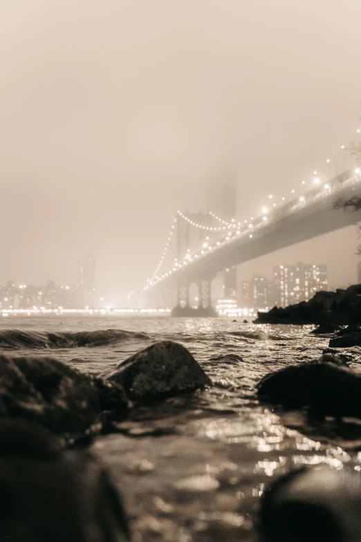 a black and white pograph of a city with a bridge